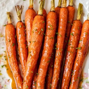 Honey glazed carrots on a white plate.