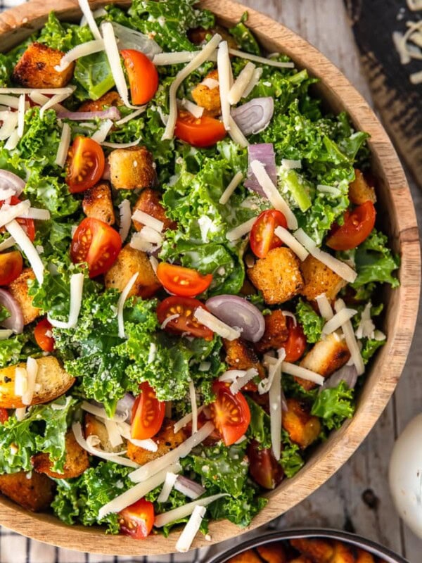 Kale Caesar Salad is the perfect side salad for any meal! It's just like a classic caesar salad, but with a twist. You've got the homemade croutons and the caesar dressing, but we're throwing in kale instead of romaine, and adding some tomatoes and shallots for extra flavor. This salad recipe is good!