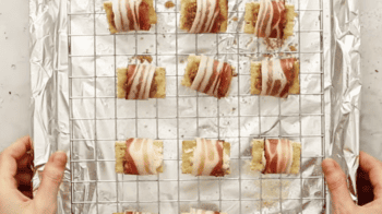 bacon wrapped crackers on a wire rack set in a baking sheet.