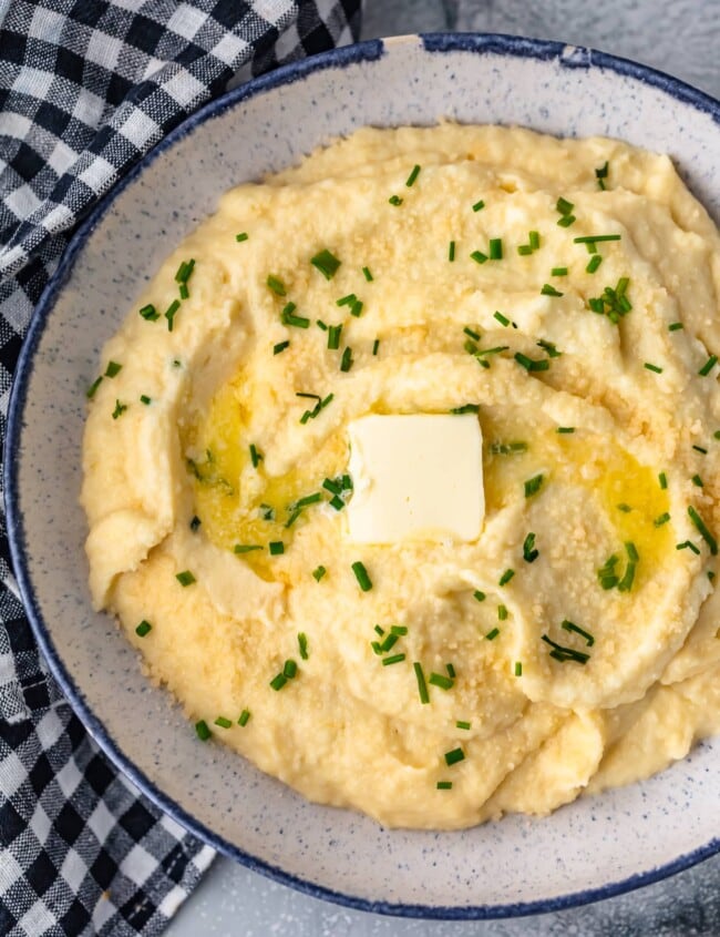 Cheesy Mashed Cauliflower is a healthy (and tasty) alternative to regular mashed potatoes. Learn how to make cauliflower mash with this simple recipe!