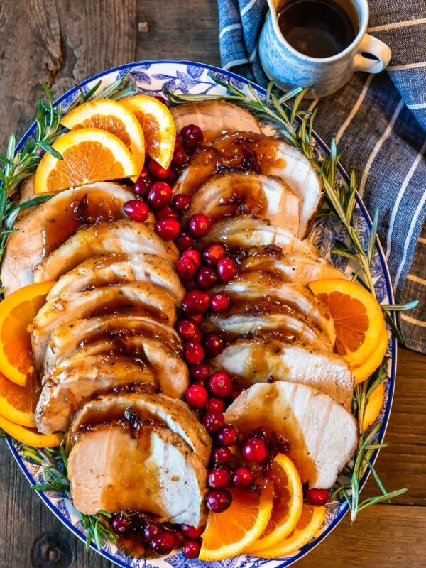 This Pork Loin Roast recipe is the perfect holiday main dish! This Orange Cranberry Pork Loin Roast is juicy, delicious, and super festive. Add this roasted pork recipe to your Thanksgiving and Christmas tables!