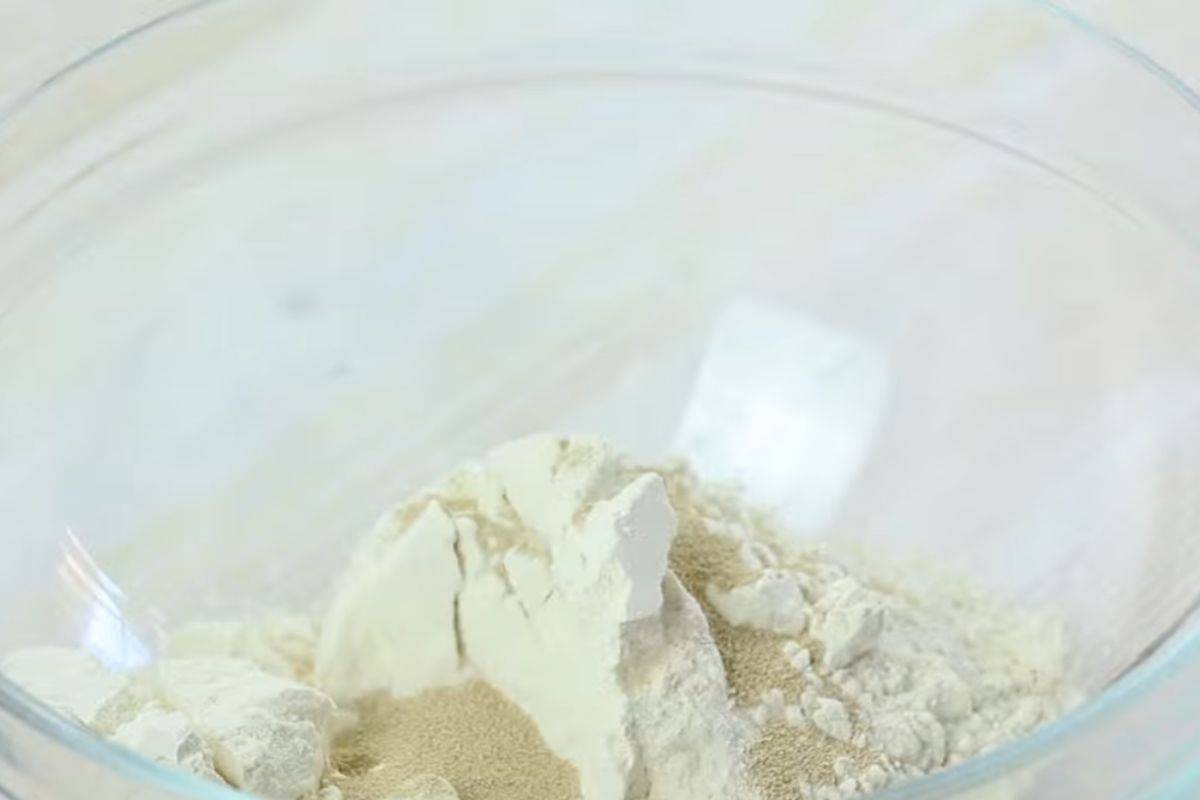 flour and yeast combined in a large glass bowl.