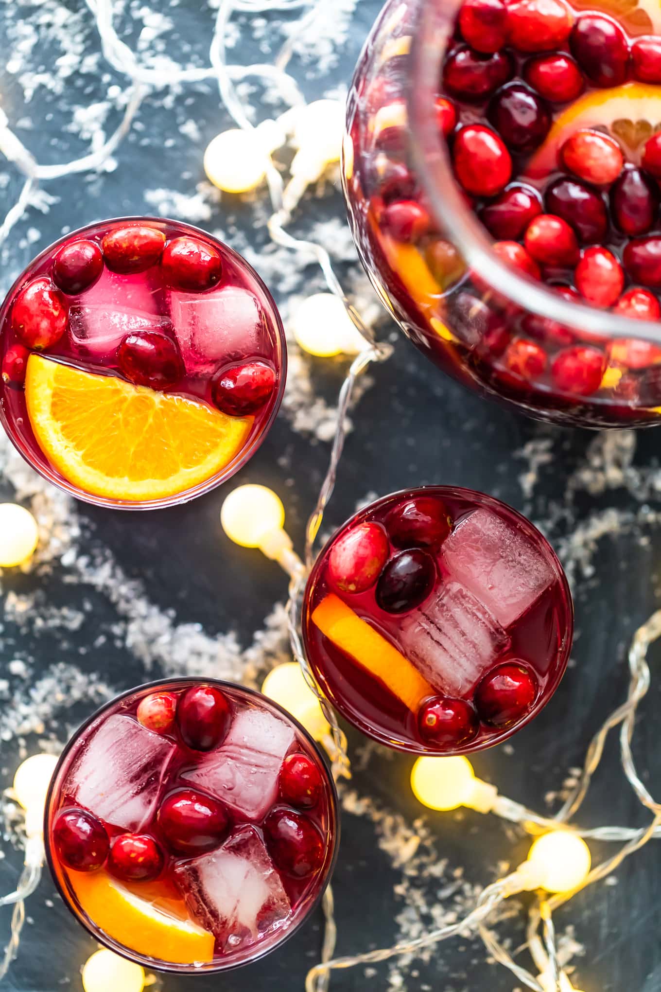 overhead view of sangria topped with cranberries and orange slices