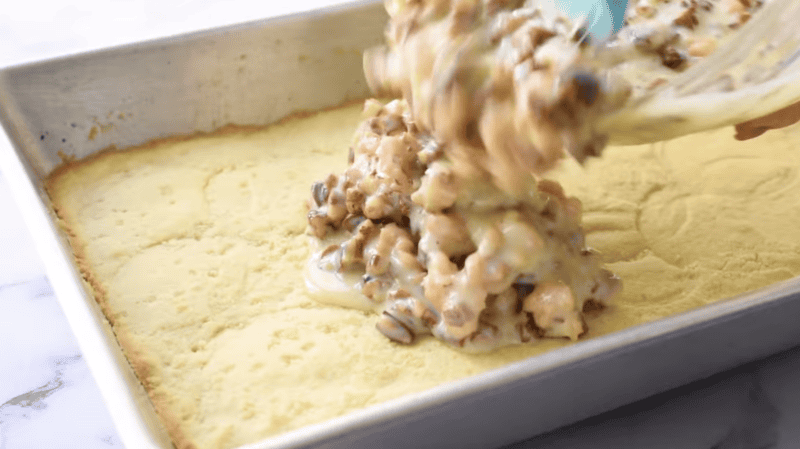 pouring pecan pie filling over baked pie crust in a baking dish.