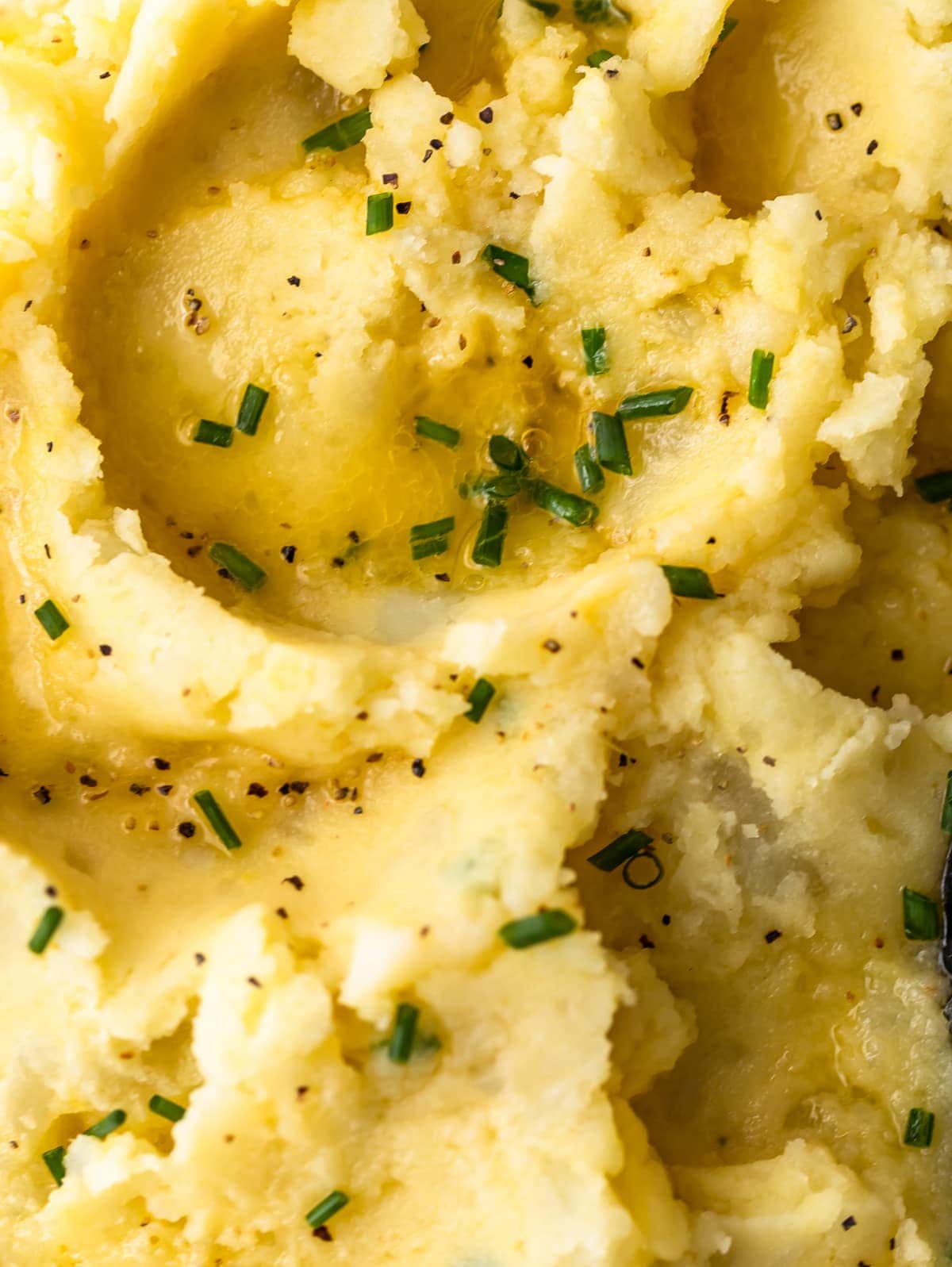 close up on creamy mashed potatoes topped with chives