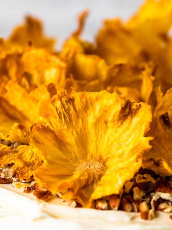 Dried Pineapple Flowers are a surprisingly easy way to make any cake look like it was decorated by a professional! Learn how to make flowers for cake out of pineapple, and every cake will look extra amazing for holidays and special occasions. Plus these dried pineapple slices make a great snack!