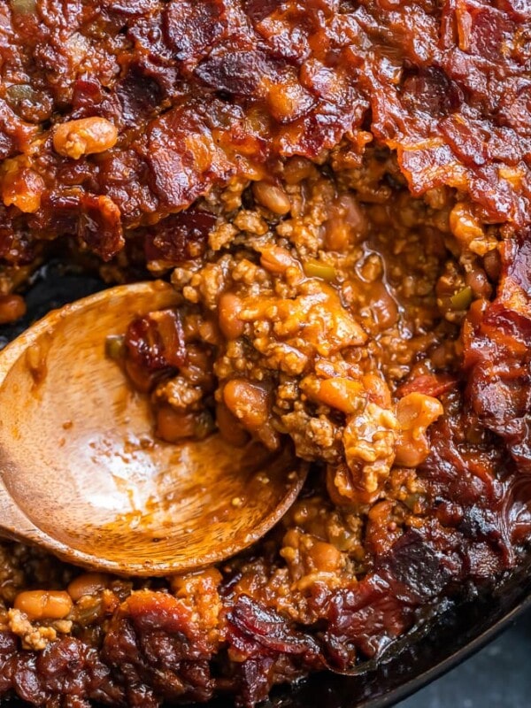 baked beans being scooped out of skillet