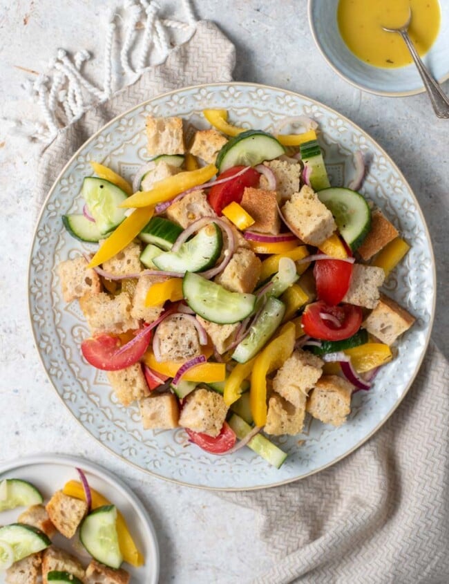 panzanella salad on plate with dressing on the side