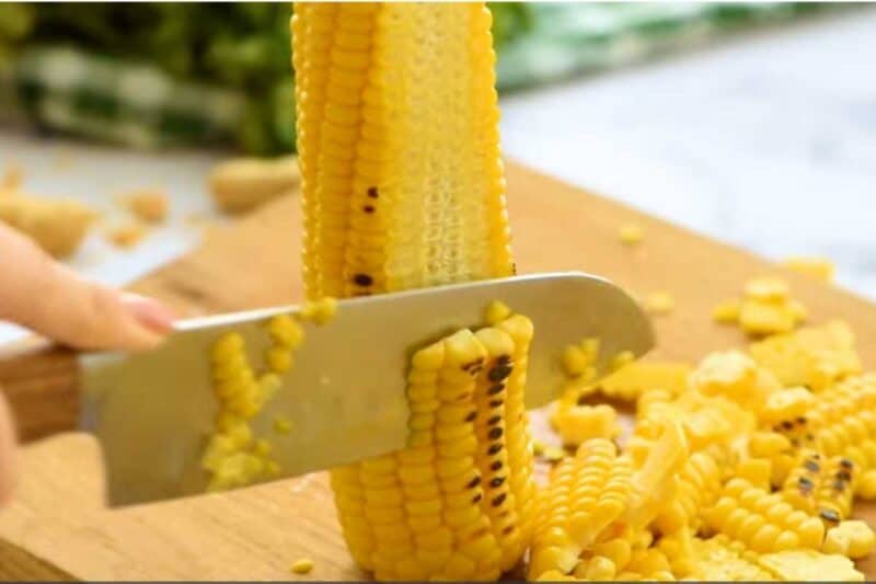 cutting all corn kernels with the help of knife.