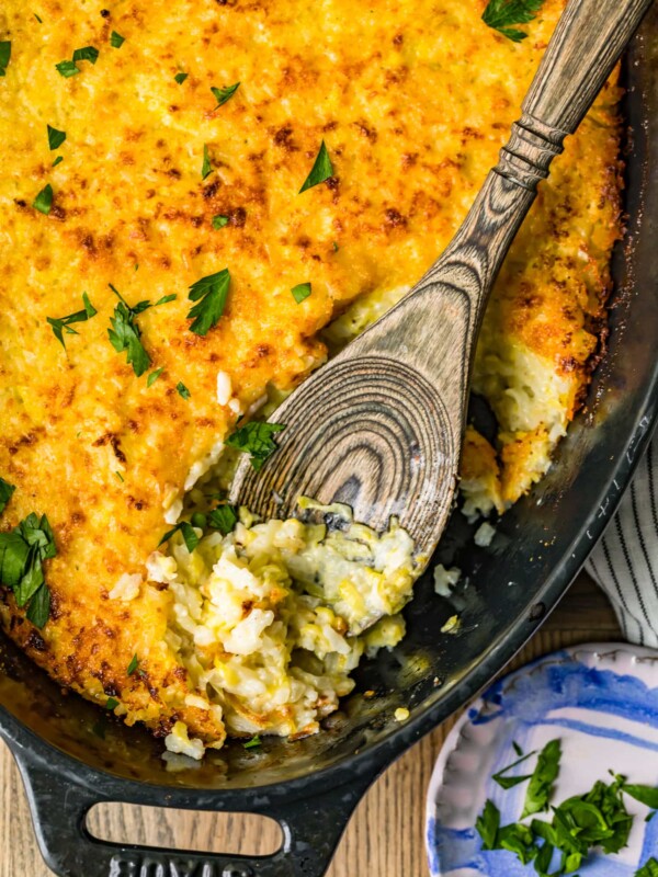 zucchini gratin in pan with wooden spoon