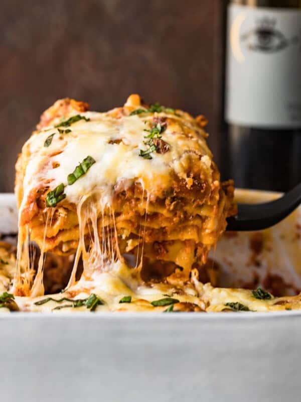 cheesy lasagna coming out of baking dish