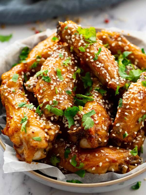 honey glazed chicken wings topped with sesame seeds and cilantro in a bowl