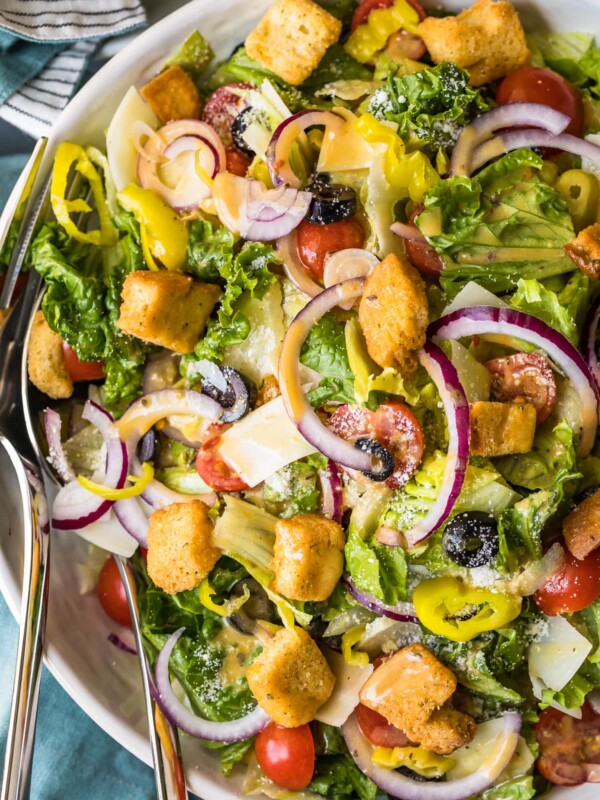 a salad full of veggies, dressing, and croutons