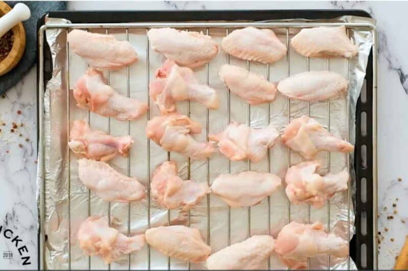 chicken wings are placed on the prepared baking sheet.