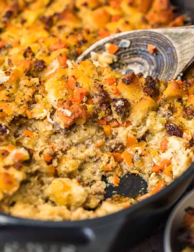 spoon scooping up sausage stuffing in skillet