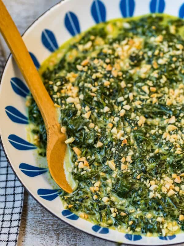 creamed spinach with toasted almonds in a bowl with spoon