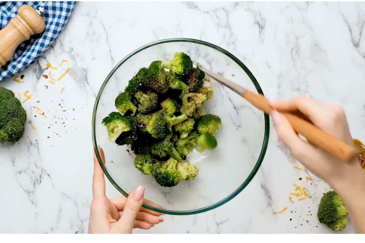 mixing broccoli florets with oil and salt