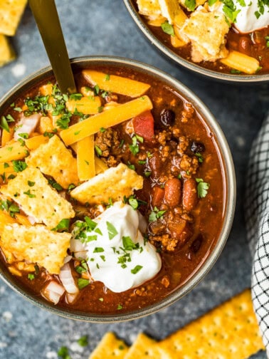 crockpot chili in a bowl with spoon with crackers