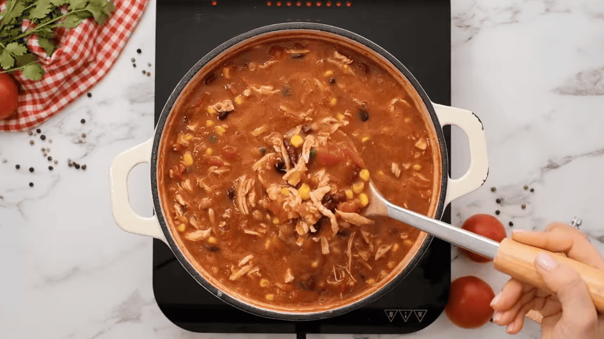 chicken taco soup in a dutch oven with a serving spoon.