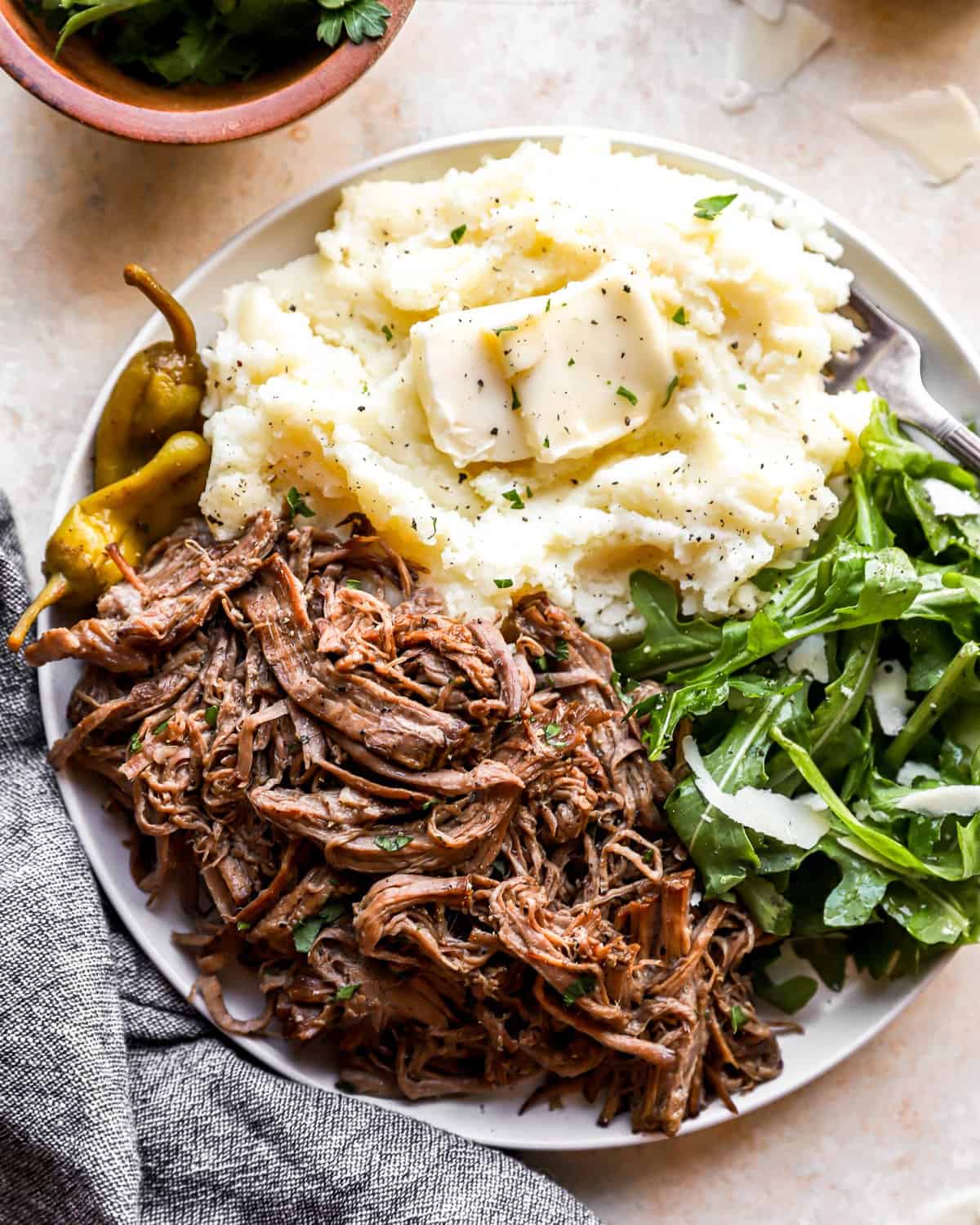 A plate with Mississippi pot roast, mashed potatoes, and beef on it.