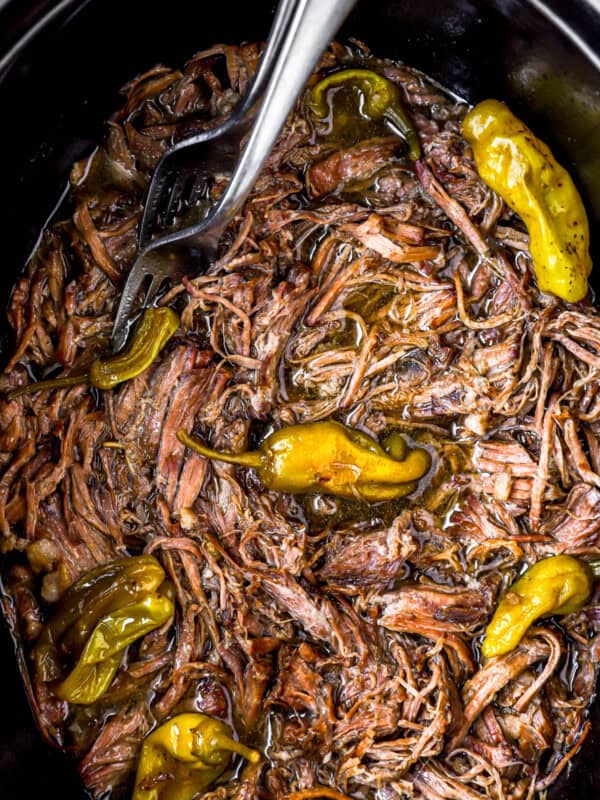 A Mississippi pot roast slow cooker full of meat and peppers.