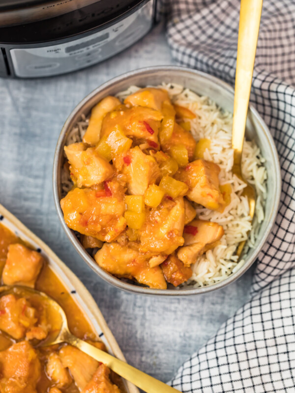 sweet and sour chicken in a bowl with a fork and rice