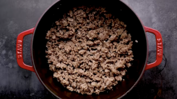 browned ground beef and sausage in a dutch oven.