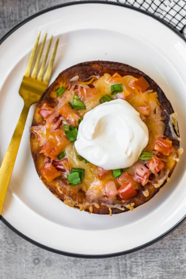 mexican tortilla pizza on plate with sour cream