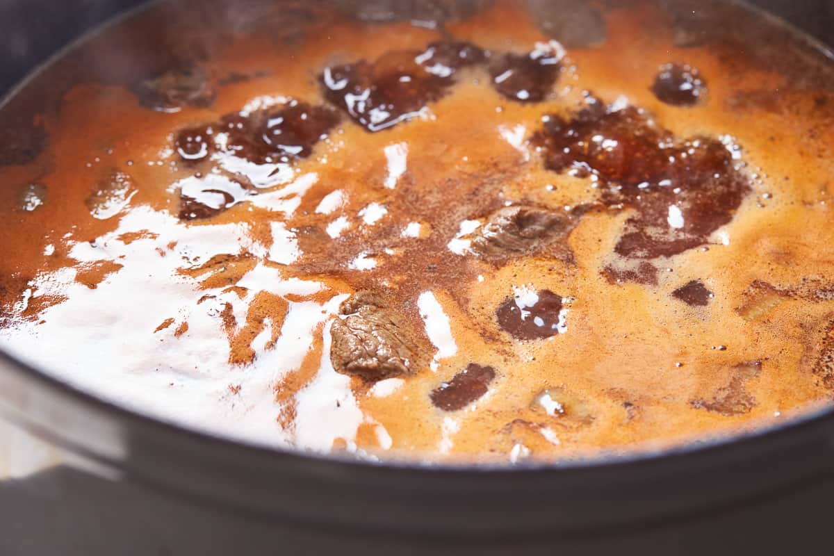 Red wine stew simmering in a Dutch oven.