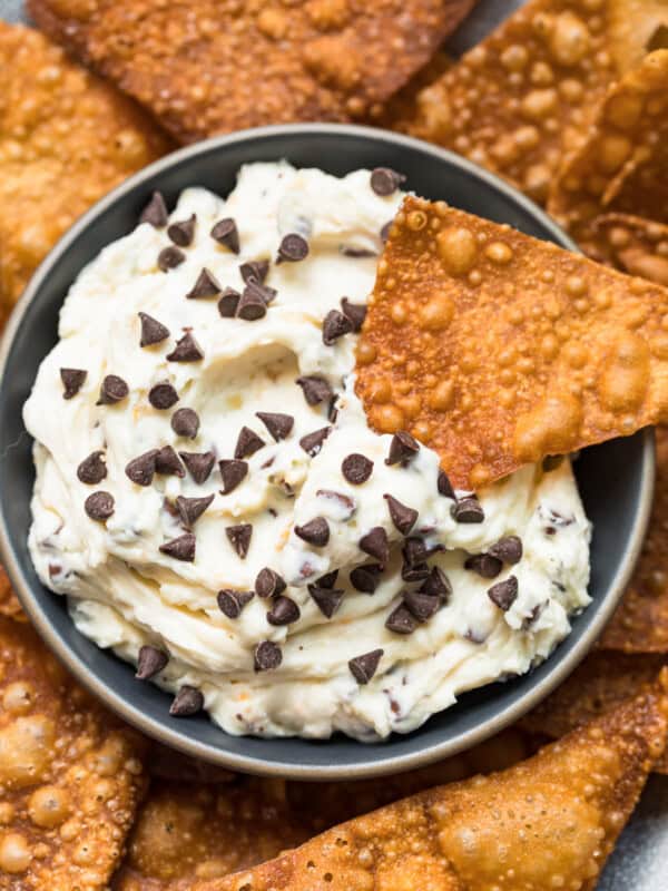 wonton chip dipping in cannoli dip with chocolate chips