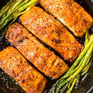 up close honey garlic salmon with asparagus in skillet