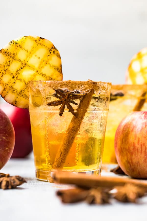 straight on photo of apple cider margarita with grilled apple and cinnamon