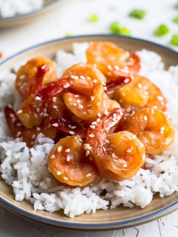 honey sesame shrimp over rice on brown plate