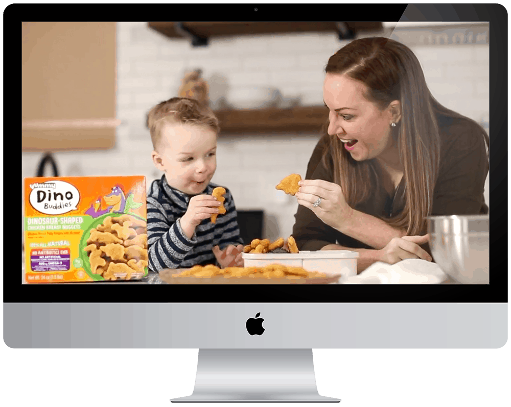 a woman and child eating chicken nuggets on a computer screen.