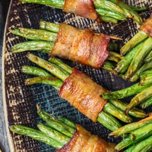 black platter with green beans wrapped in bacon