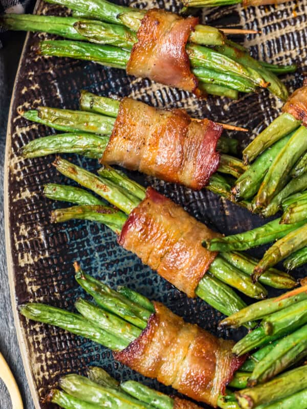 black platter with green beans wrapped in bacon