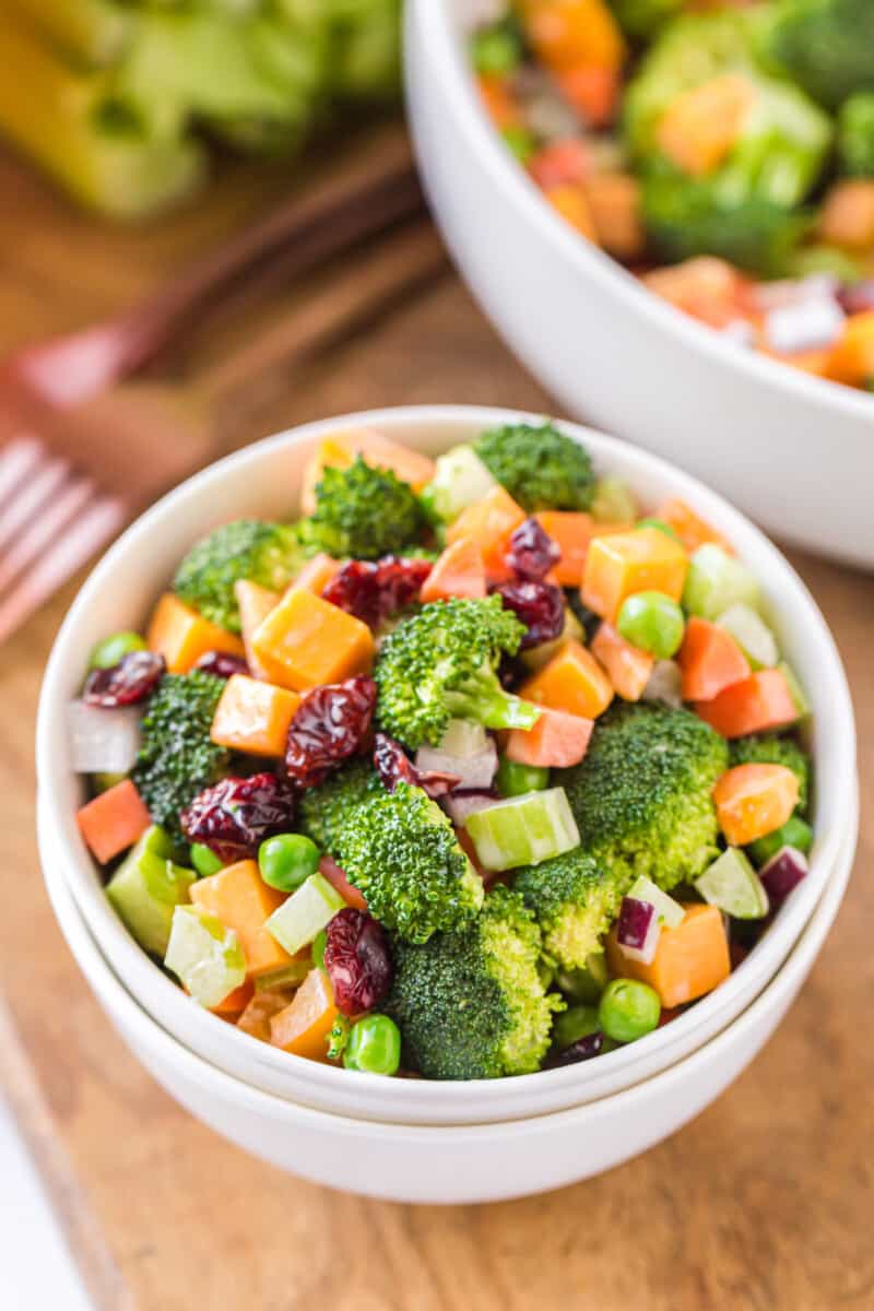 cheesy broccoli salad in white bowls