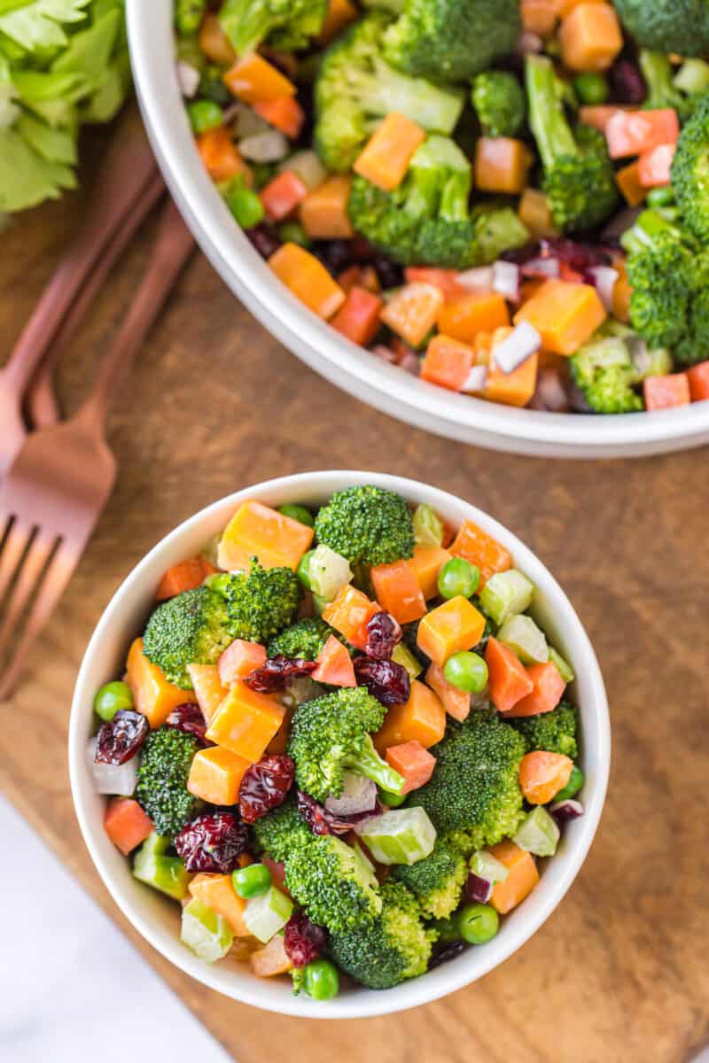 two white bowls with cheesy broccoli salad