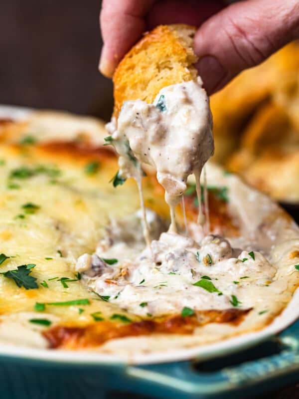 dipping toasted bread in philly cheesesteak dip