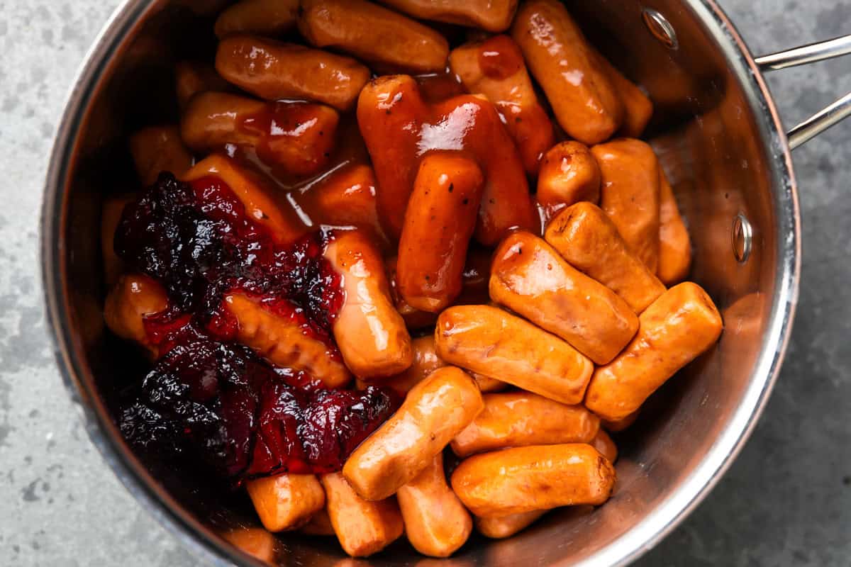 overhead view of cocktail sausages, grape jelly, and bbq sauce in a pan.