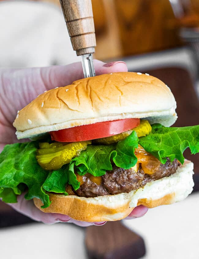 holding up air fryer cheeseburger