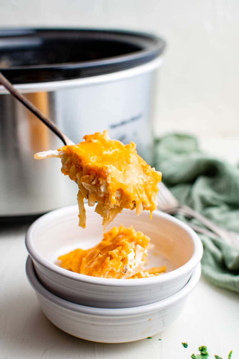 lifting up fork with cheesy hashbrown casserole