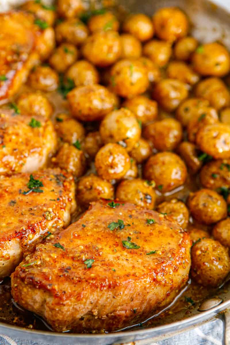 honey mustard pork chops and potatoes in skillet