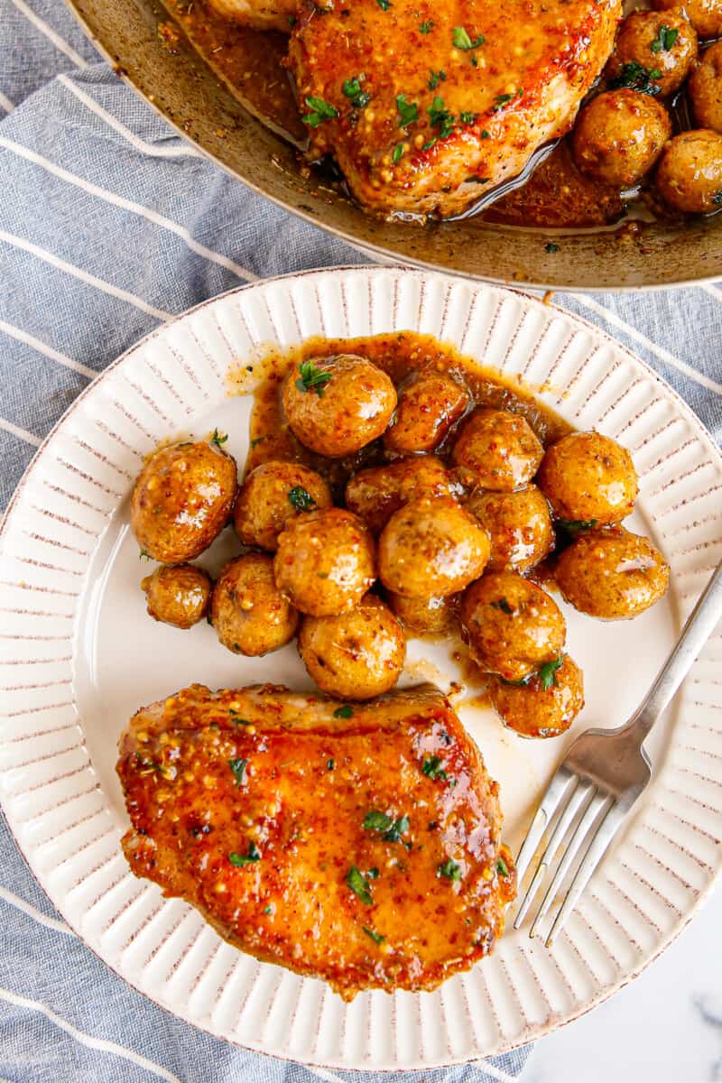 honey mustard pork chop with potatoes on white plate