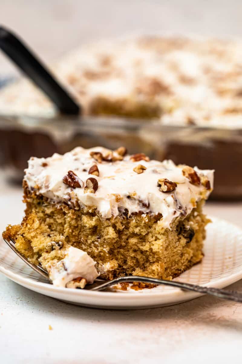 slice of italian cream cake with Cream Cheese Pecan Frosting with bite out