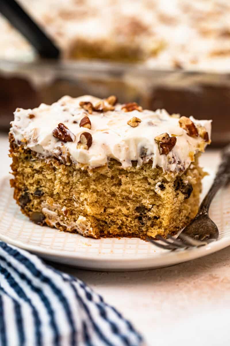 slice of italian cream cake with Cream Cheese Pecan Frosting with bite out