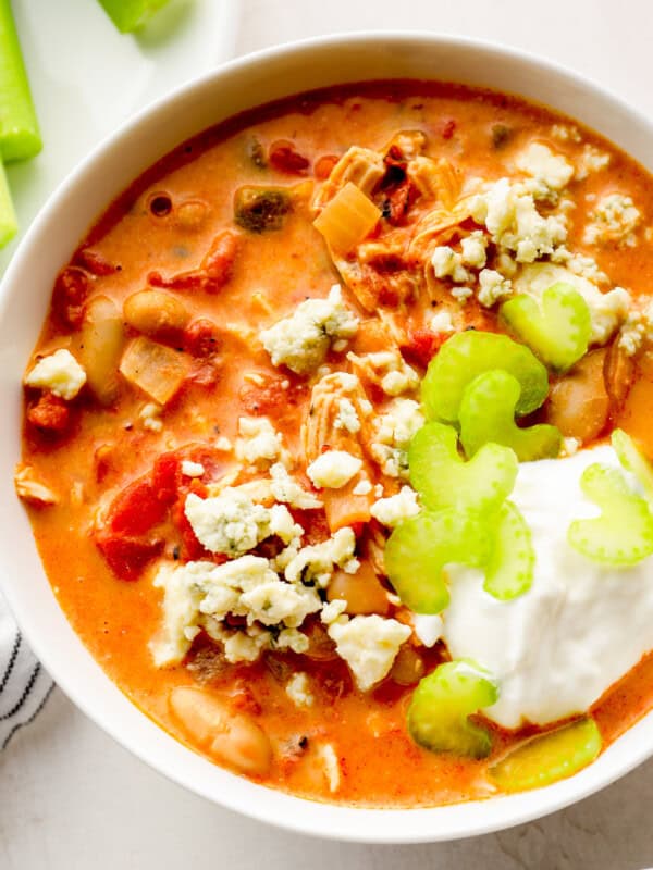 up close buffalo chicken chili garnished with sour cream, blue cheese, and celery