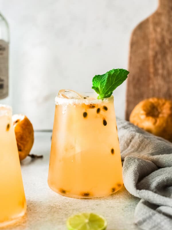 two glasses of passionfruit margaritas garnished with fresh mint