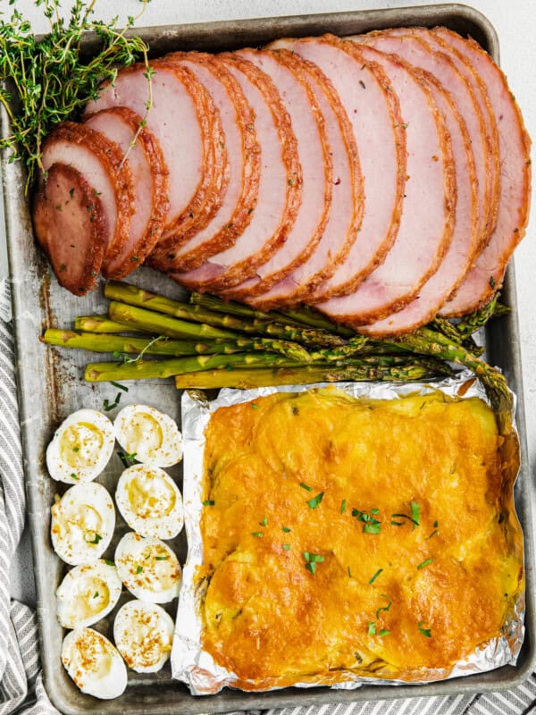 sheet pan easter dinner with ham, scalloped potatoes, hard boiled eggs, and asparagus