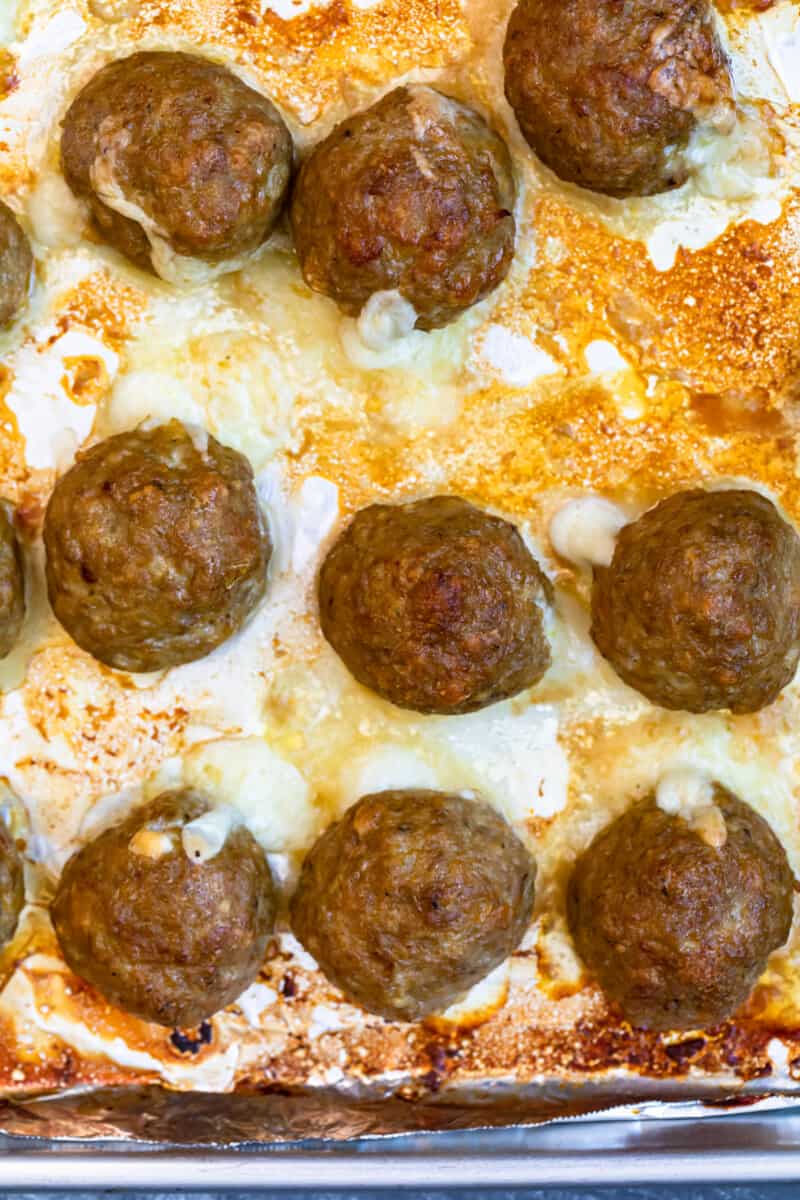 overhead cheesy baked turkey meatballs on sheet pan